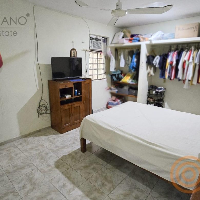 Recámara con clóset abierto y TV
