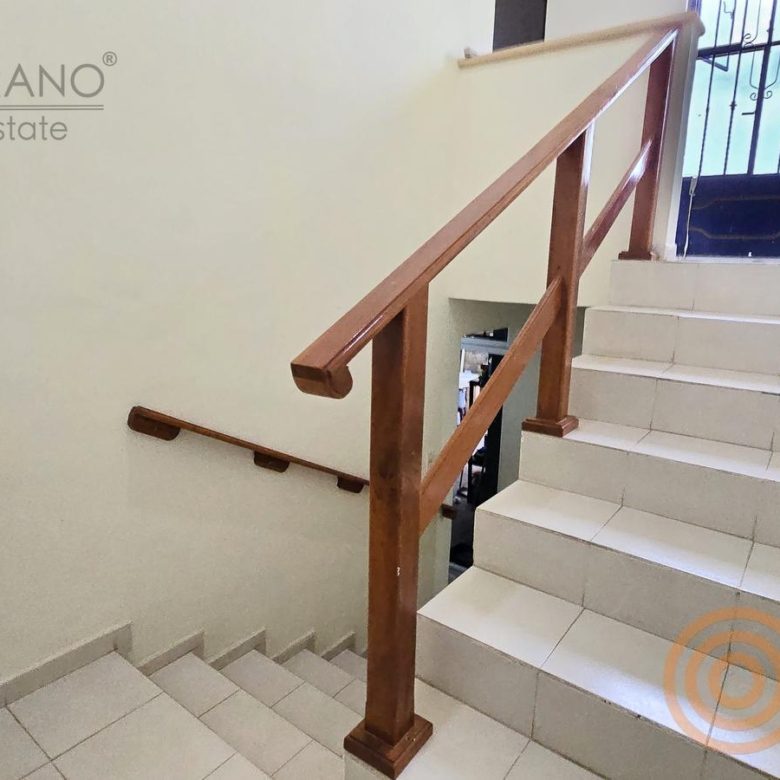 Escalera con barandal de madera hacia la planta alta