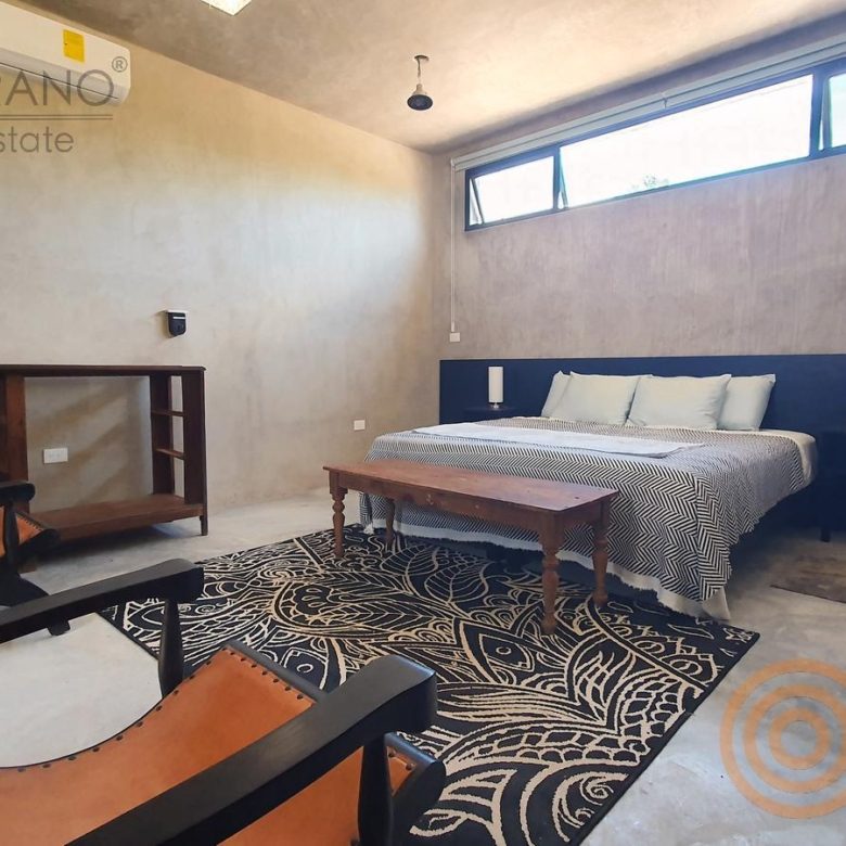 Habitación king con ventana alta y mobiliario de madera