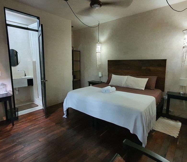 Habitación con cama king, madera y baño privado