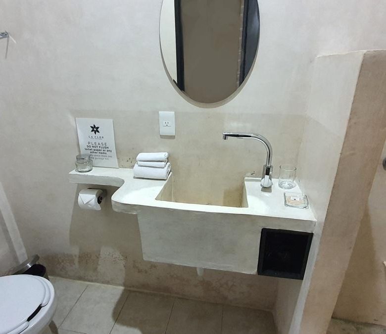 Baño con lavabo de concreto pulido y regadera