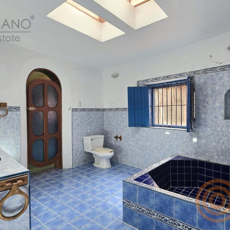 Baño con tina de azulejo azul y lavabo de talavera