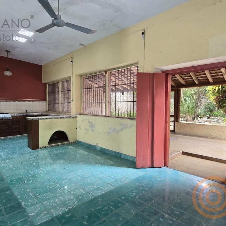 Cocina con ventanales al jardín y piso turquesa