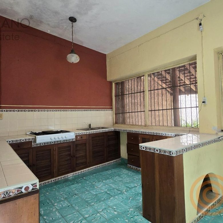 Cocina con barra, gabinetes de madera y azulejos decorados