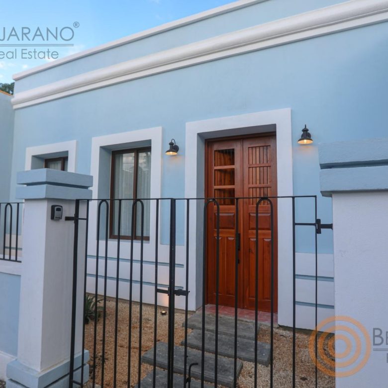 Puerta de madera y buganvilia en la entrada de la casa colonial