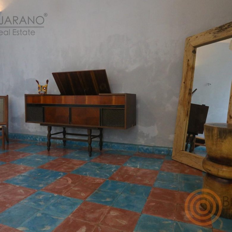 Aparador de madera y espejo con marco rústico sobre el piso de mosaico