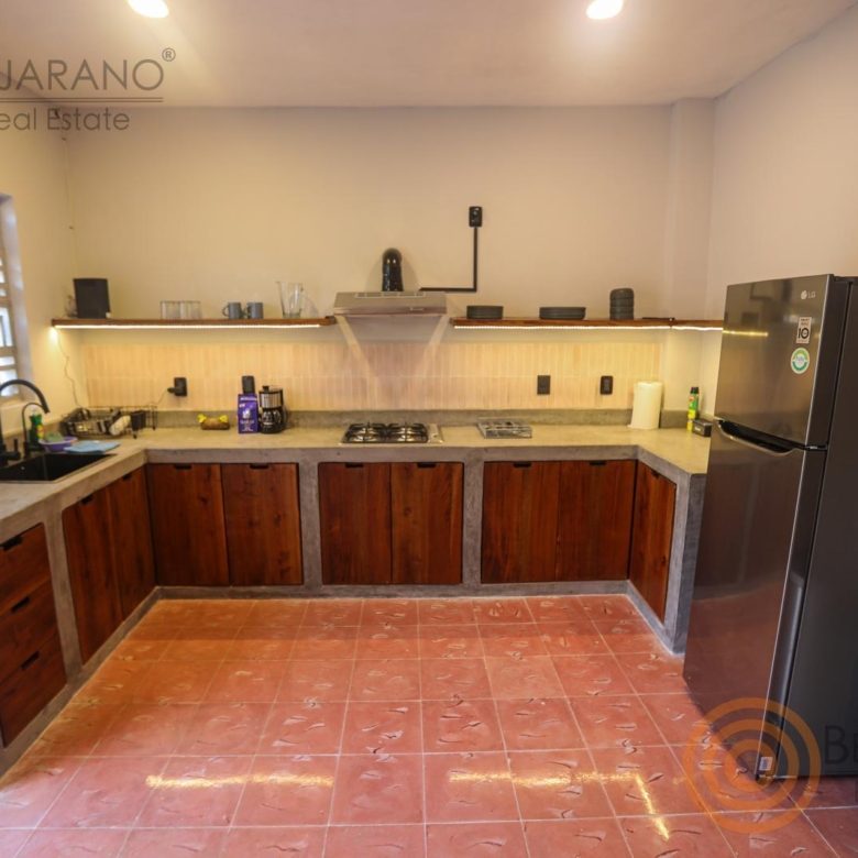 Cocina equipada con gabinetes de madera y refrigerador