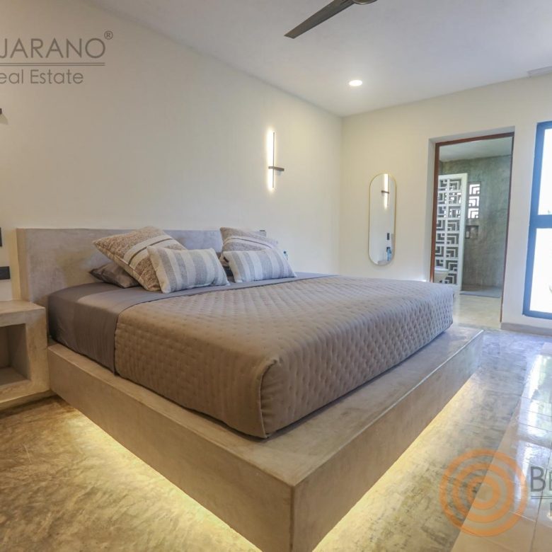 Recámara principal con cama flotante e iluminación cálida