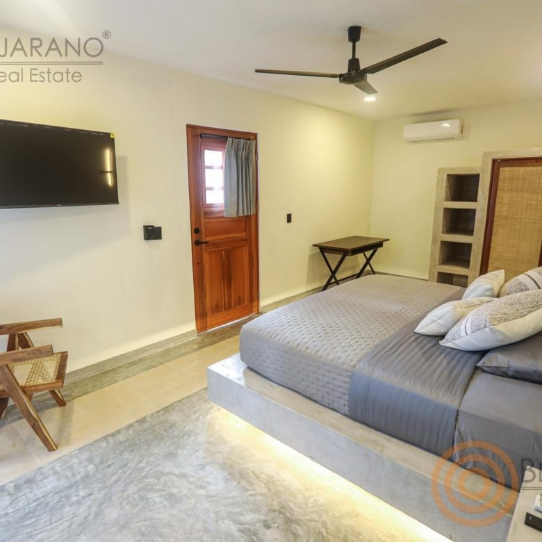 Recámara con TV, ventilador de techo y clóset de ratán