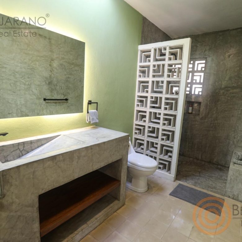 Baño con lavabo de concreto pulido y celosía de diseño