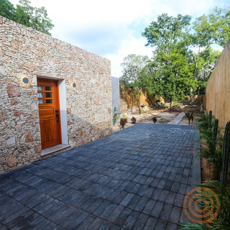 Patio con muro de piedra y andador de adoquín azul