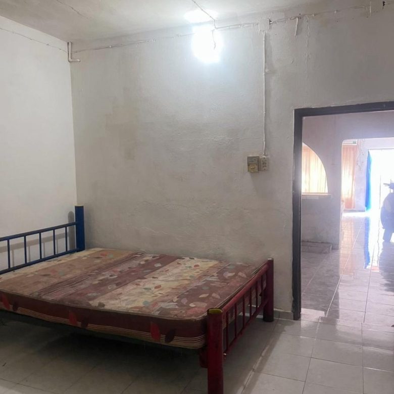 Recámara con cama y acceso al pasillo