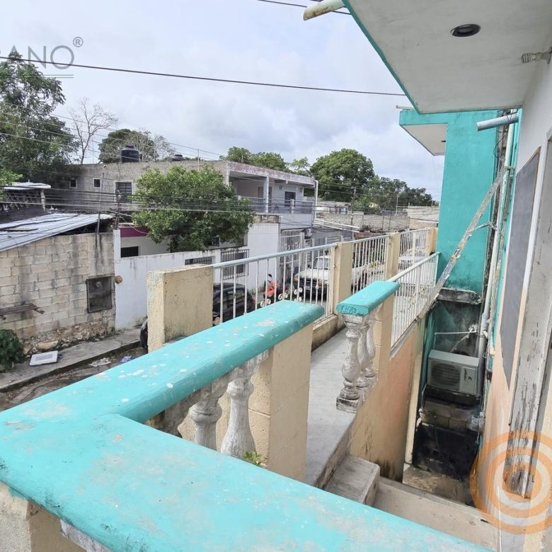 Balcón con barandal turquesa sobre la calle