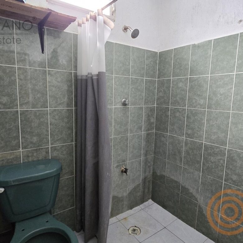 Baño con regadera de azulejo verde