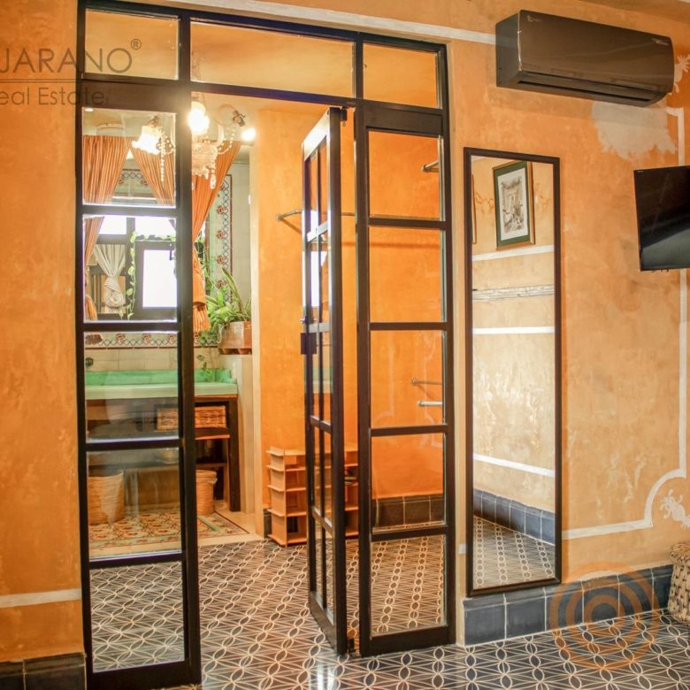 Recámara con piso de mosaico y puertas de herrería con vidrio