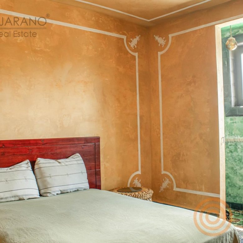 Cama y ventana de la recámara con muros pintados a mano
