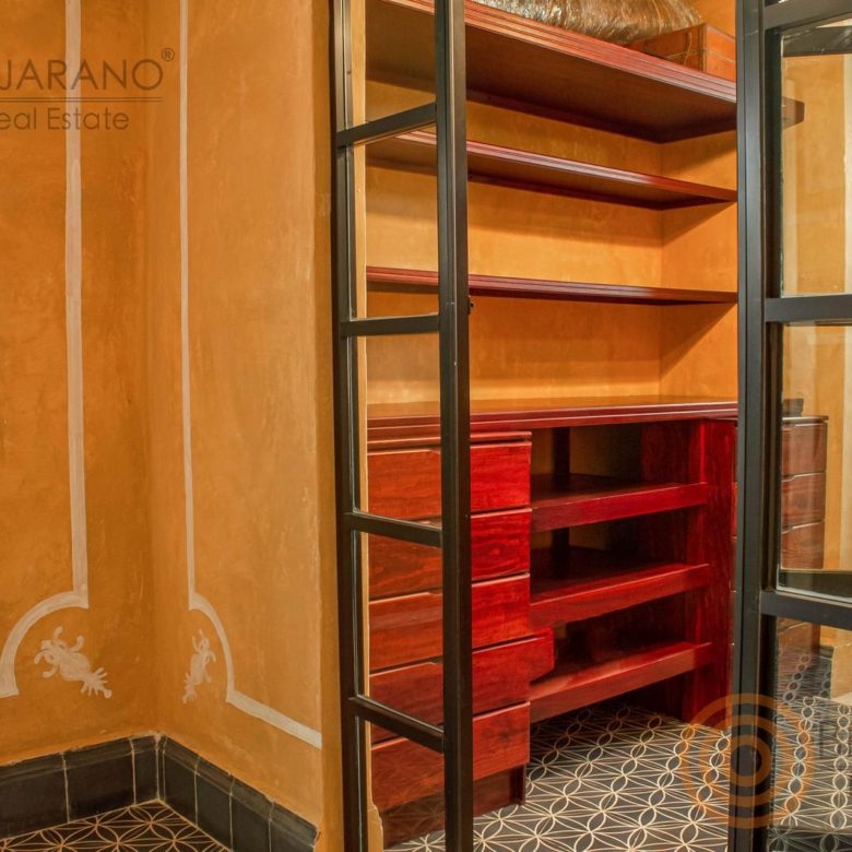 Vestidor con repisas de madera y puerta de herrería