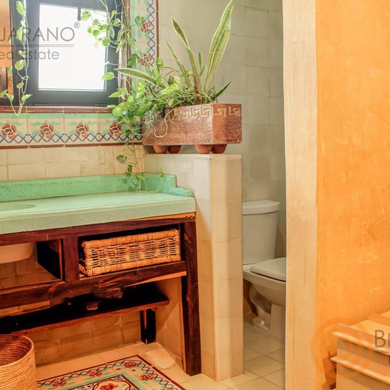 Lavabo verde y detalles de madera en el baño