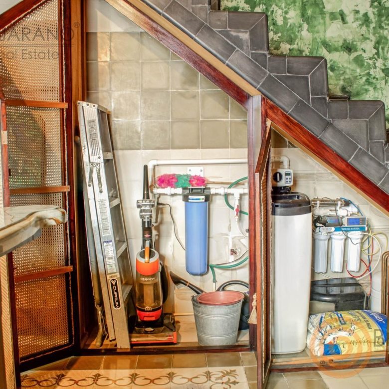 Espacio de servicio bajo la escalera con filtros de agua