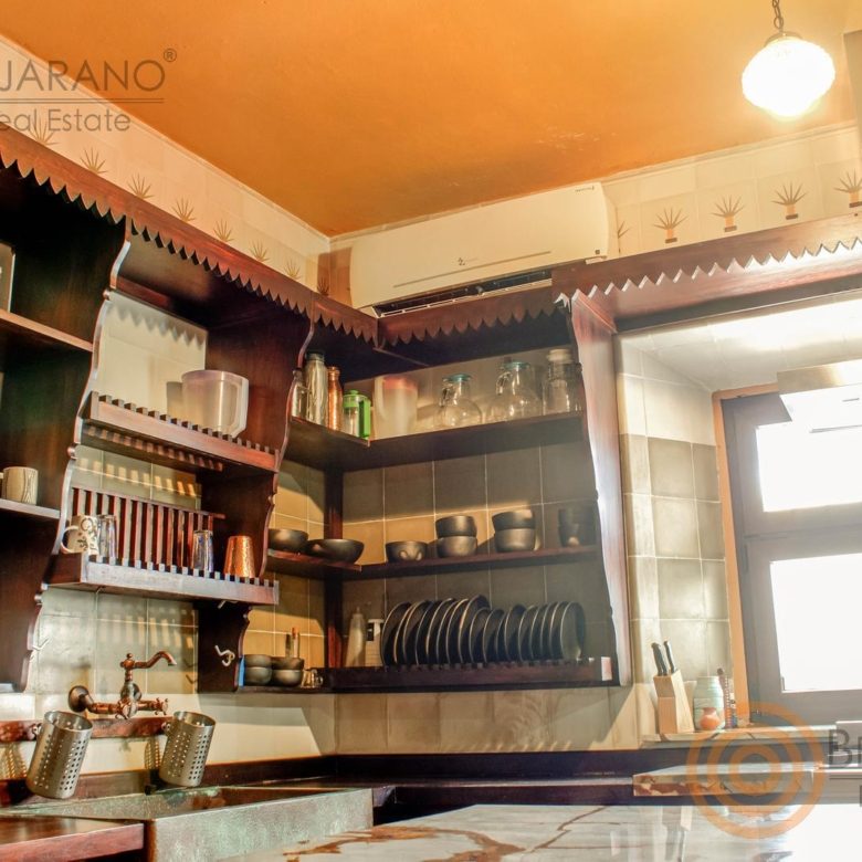 Esquina de la cocina con repisas de madera y vajilla