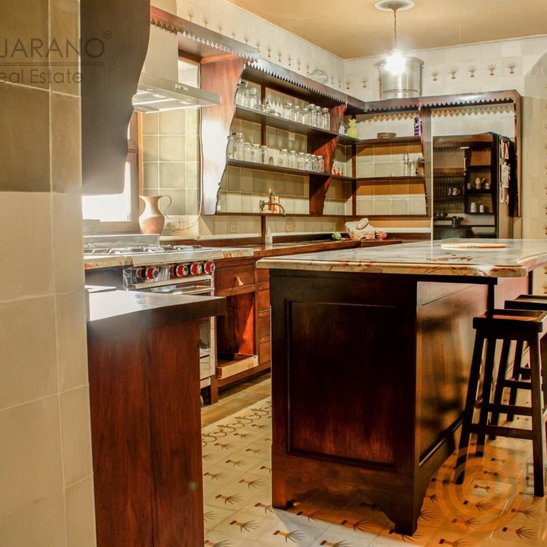 Cocina con isla y barra de bancos de madera