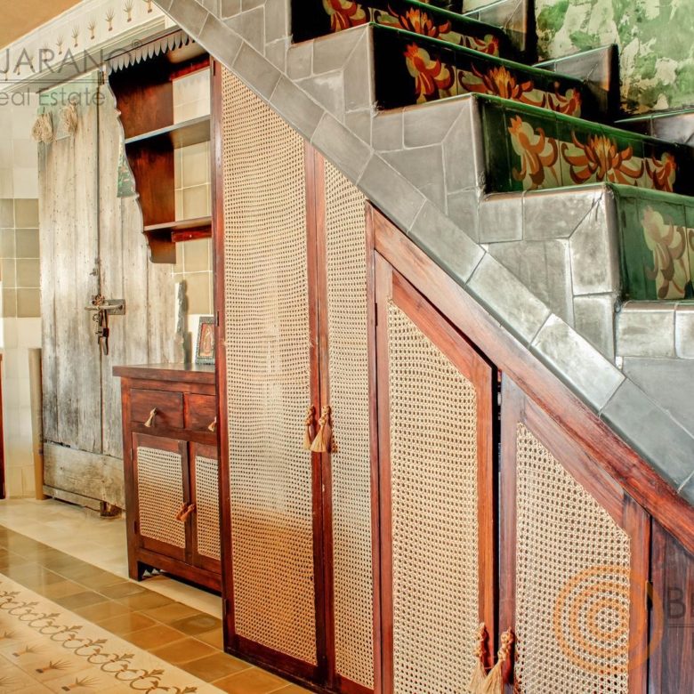 Escalera con peldaños decorados y alacena de ratán