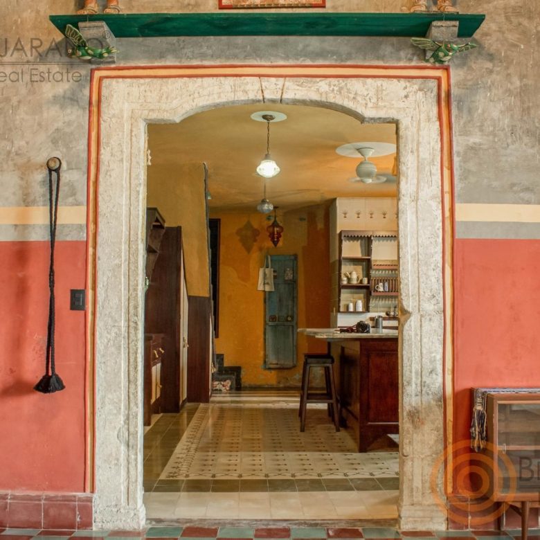 Entrada a la cocina con marco de cantera y piso de mosaico