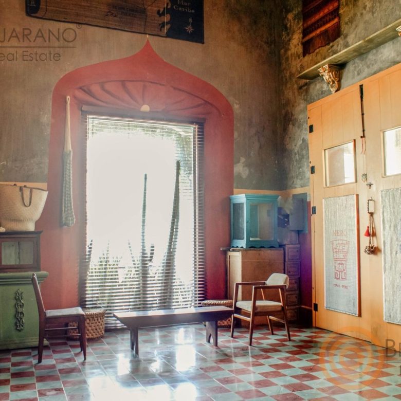 Sala con arco rojo, ventanal y piso de pasta