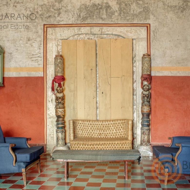 Sala con sillones azules y puerta de madera antigua