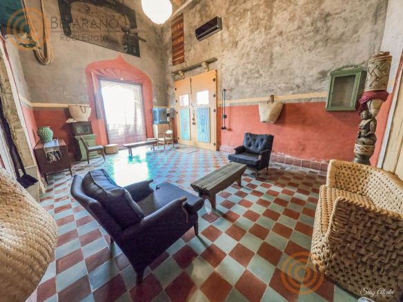 Sala amplia con piso de mosaico y sillones de ratán