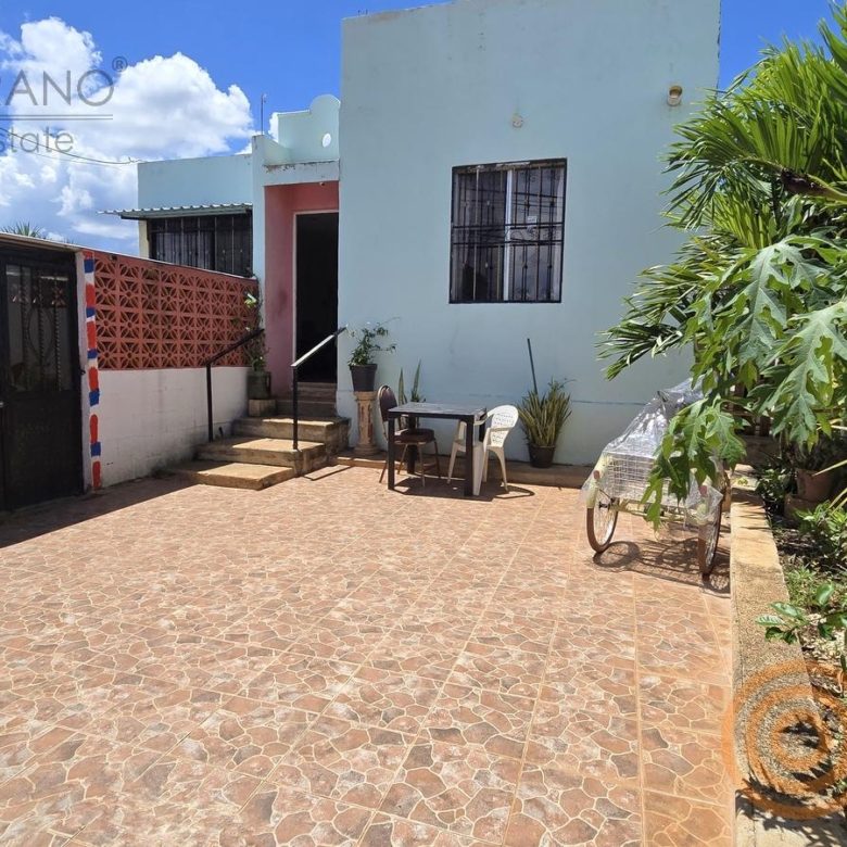 Patio frontal con piso de color y acceso a la casa