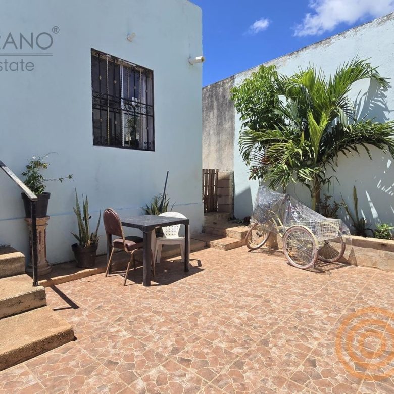 Entrada de la casa con escalones y ventana con reja