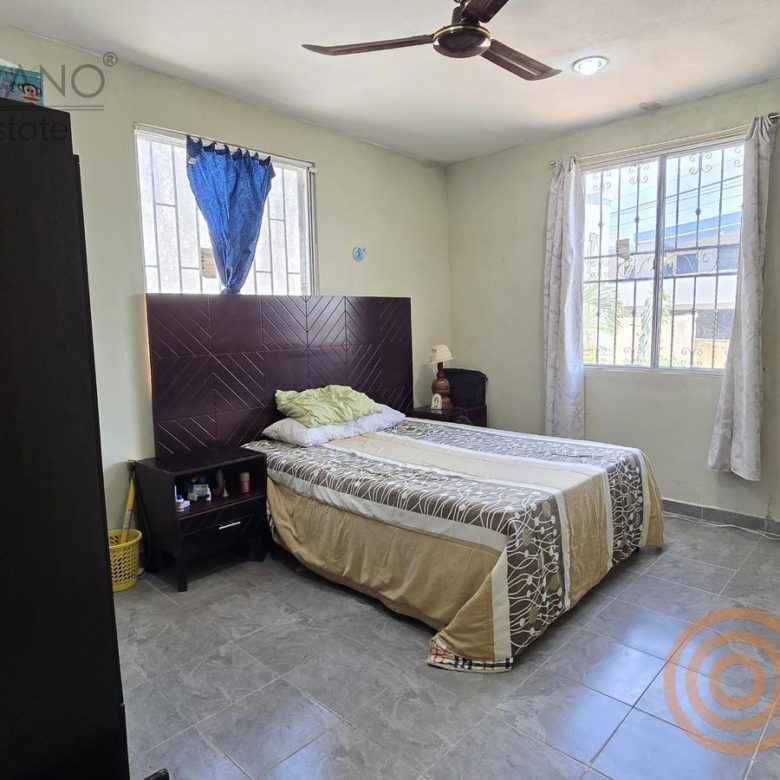 Recámara con cama, buró y ventilador de techo