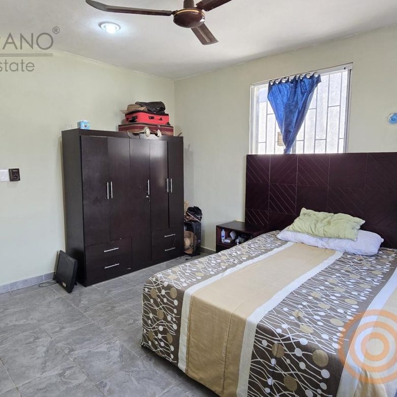 Recámara con cama, ropero y puerta a otra habitación