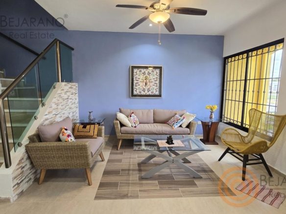 Sala amueblada con escalera de cristal y muro azul