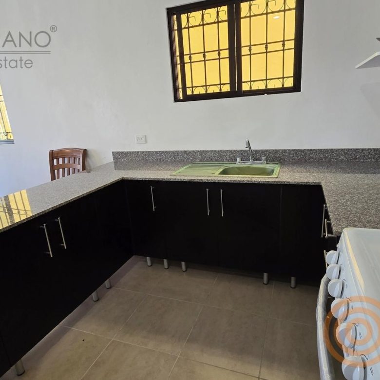 Cocina con barra de granito y gabinetes oscuros