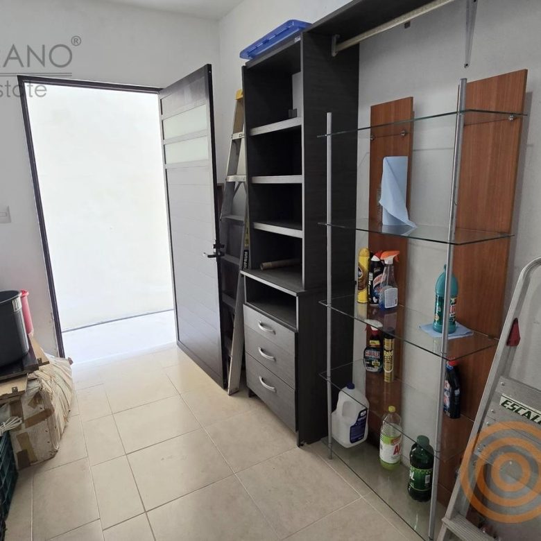 Área de servicio con estantes y salida al patio