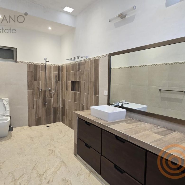 Baño amplio con tocador largo, espejo y regadera
