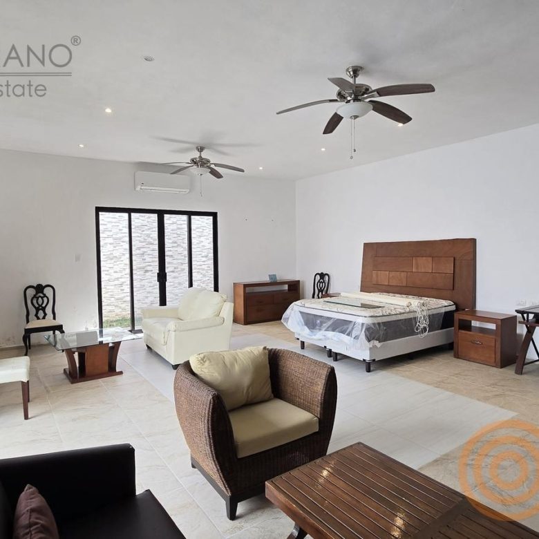 Recámara principal con cama, sala privada y puerta al patio