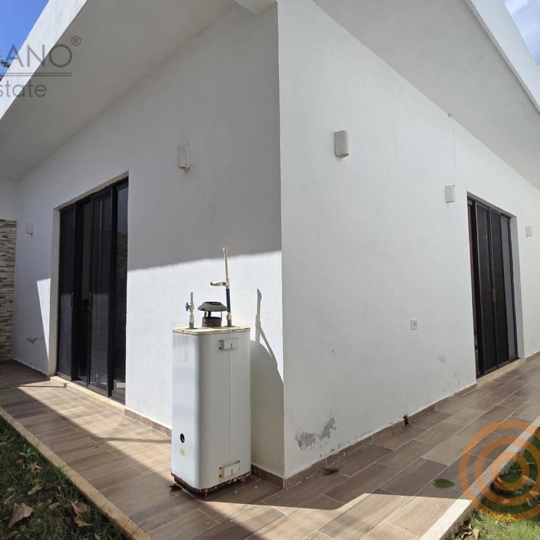 Patio trasero con pasto y área de lavado