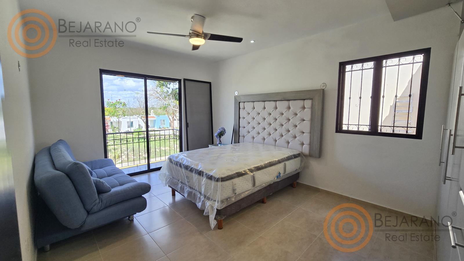 bre-cv-privstluc-a-20 Recámara con cama, sillón azul y ventana al balcón