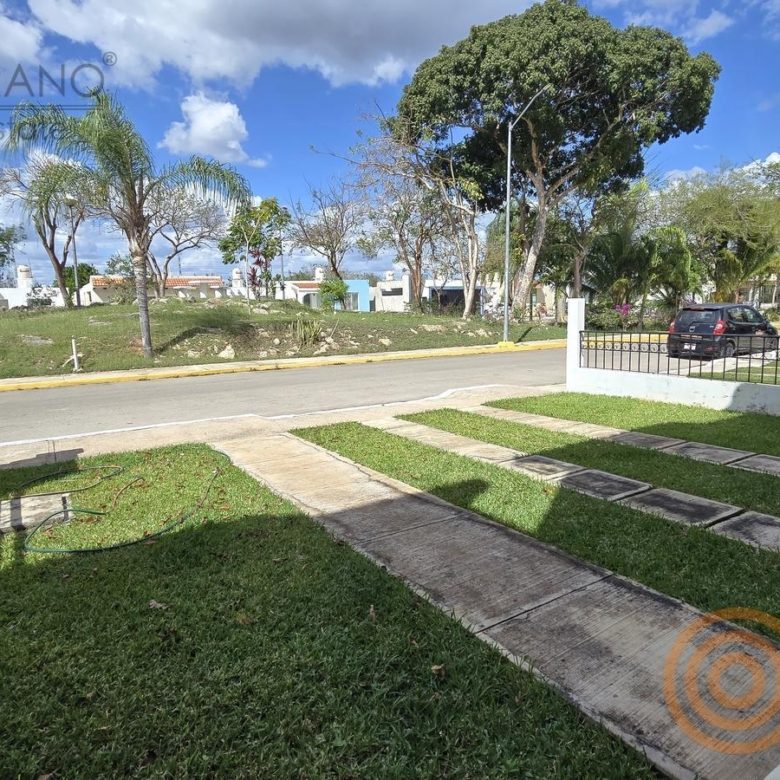 Frente de la casa con jardín y calle interna de la privada