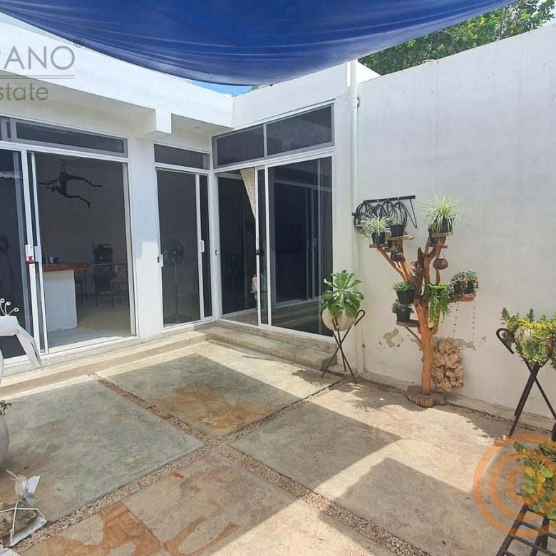 Patio interior con piso de cantera, plantas y pérgola