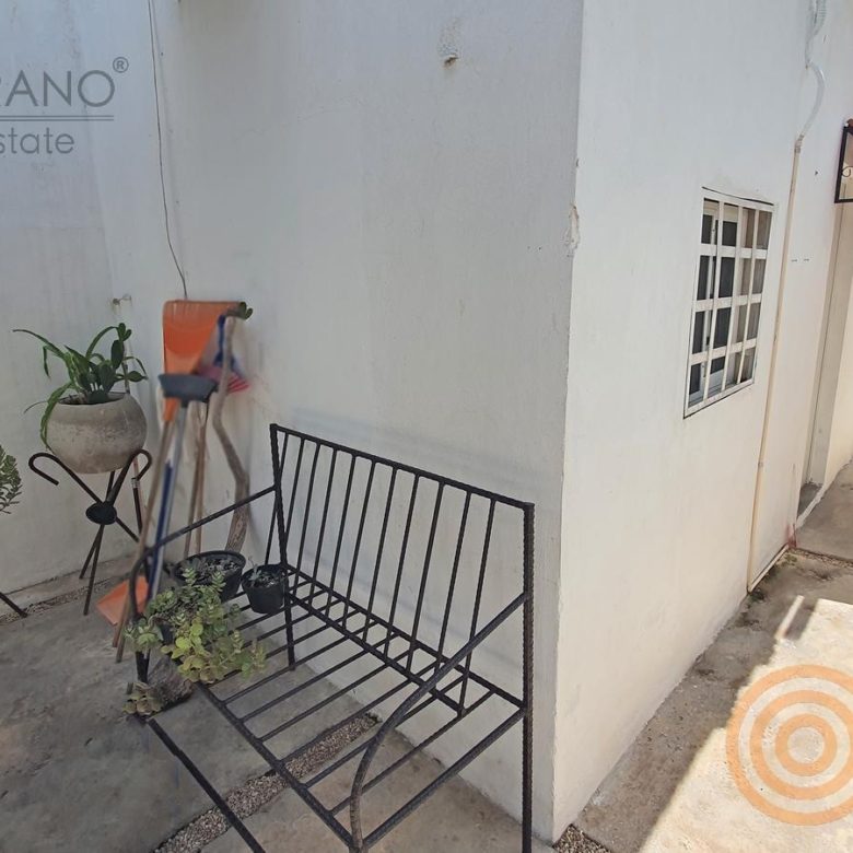 Pasillo lateral con plantas y banca