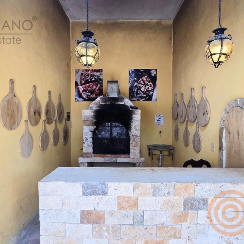Horno de leña de la pizzería con lámparas y utensilios