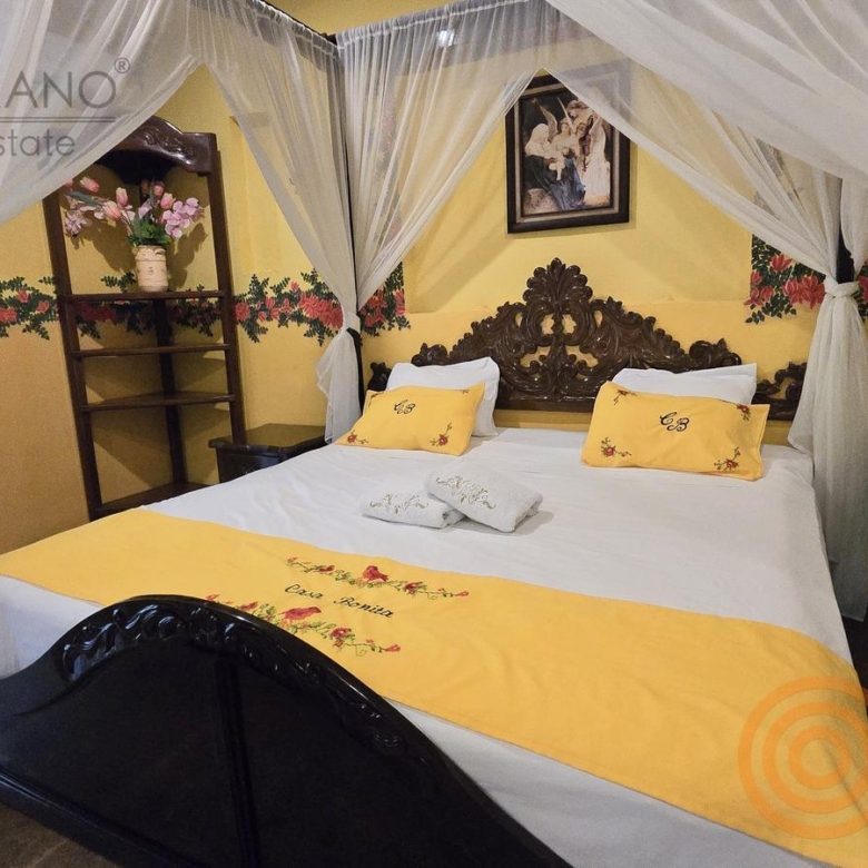 Habitación con cama de dosel y colchas amarillas