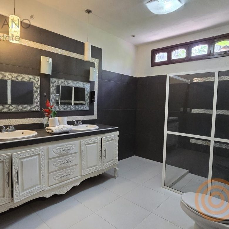Baño con doble lavabo y regadera de cristal
