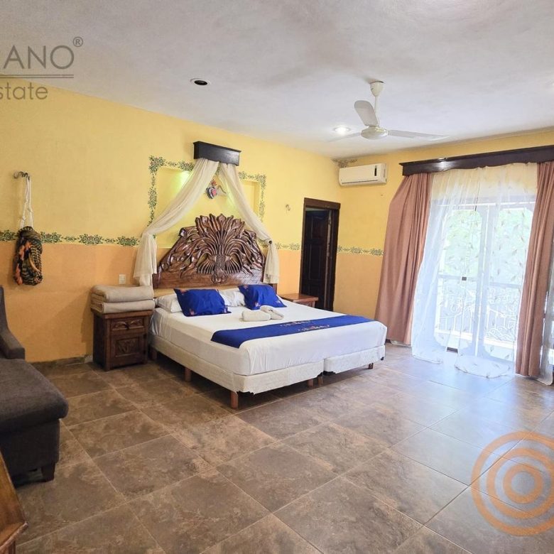 Habitación con cama, sala y ventana al jardín