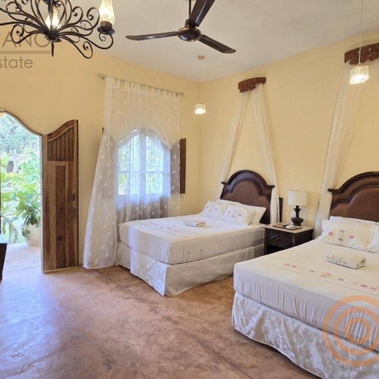 Habitación con dos camas dobles y dosel