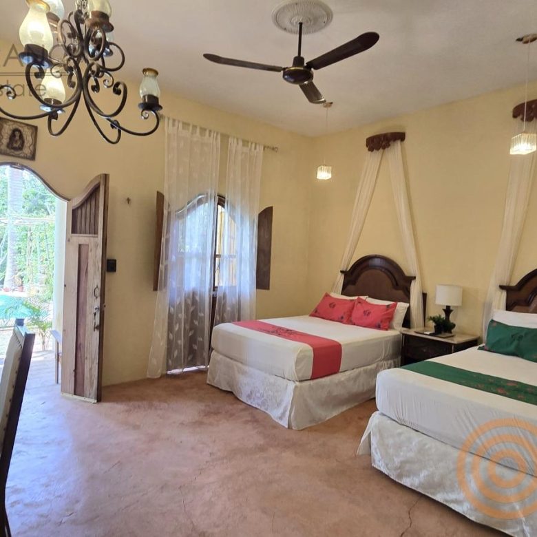 Habitación con dos camas y ventilador de techo